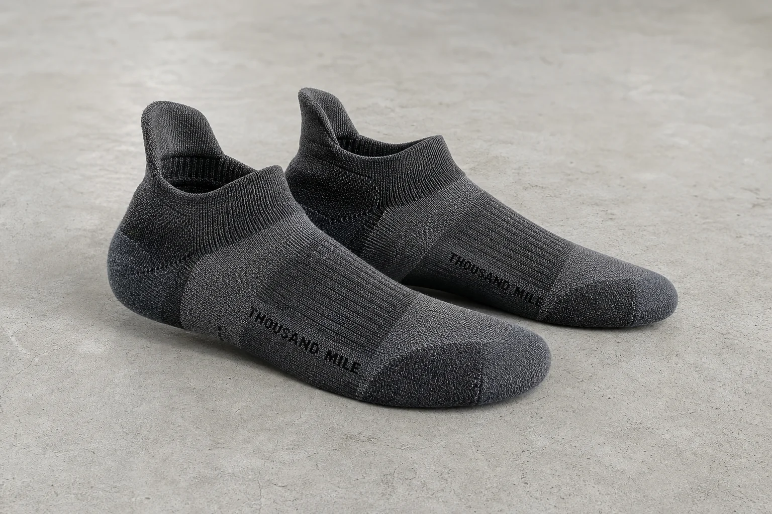 Collection of various running socks in different colors and styles on neutral backdrop