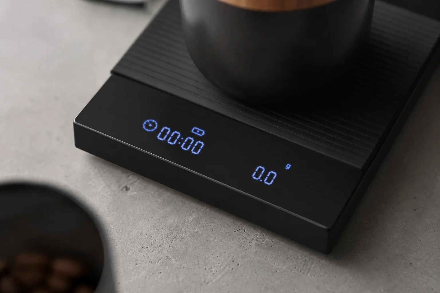 Close-up of a coffee scale display showing bright blue LED numbers and timer