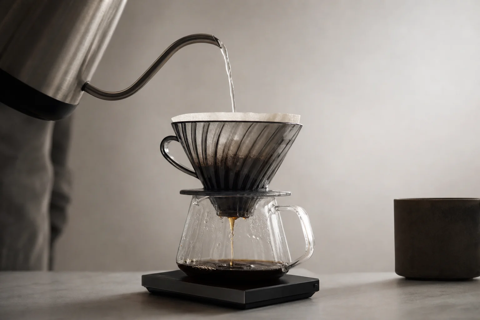 Pour over coffee setup with a scale measuring water flow into a dripper