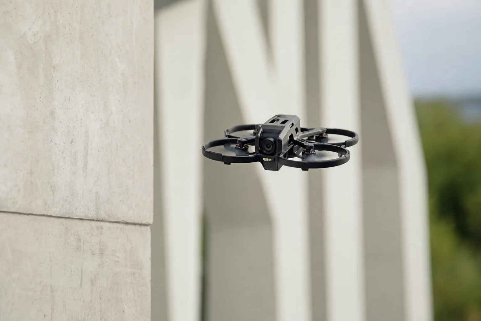 Cinewhoop-Drohne mit Schaumstoff-Propellerschutz im Flug in der Nähe von Außenstrukturen