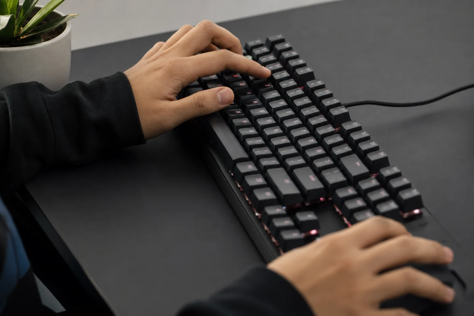 Hände eines Spielers an einer Tastatur während einer aktiven Gaming-Session