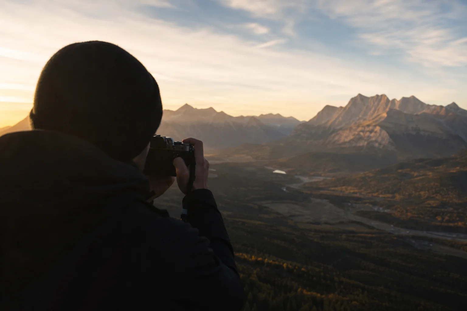 Fotógrafo de paisajes usando una cámara compacta en un mirador de montaña