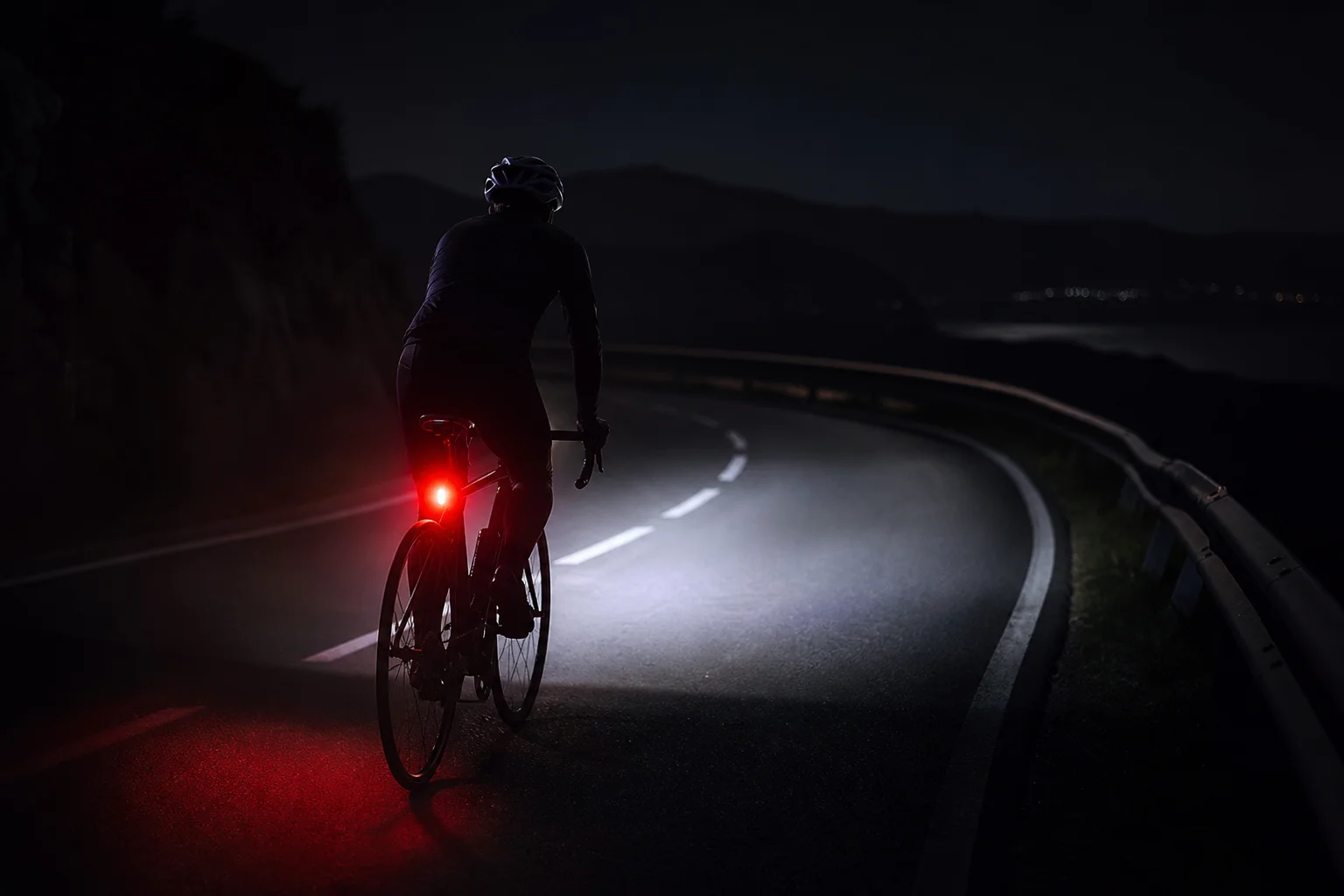 Radfahrer bei Nacht mit koordiniertem Scheinwerfer- und Rücklichtsystem