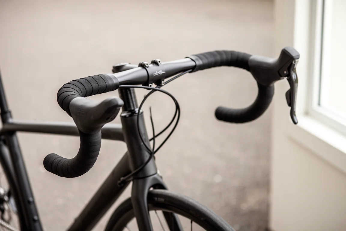Primo piano del manubrio di una bici da corsa con leve strette e curve svasate