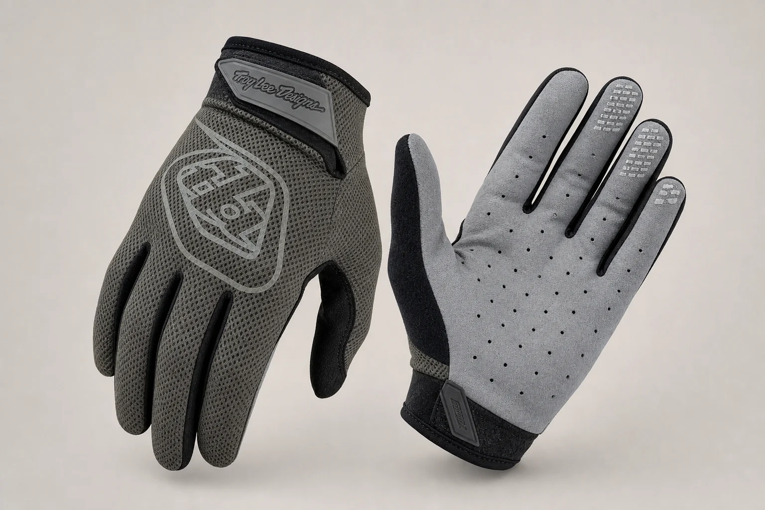 Five mountain bike gloves arranged on concrete showing different designs and protection levels