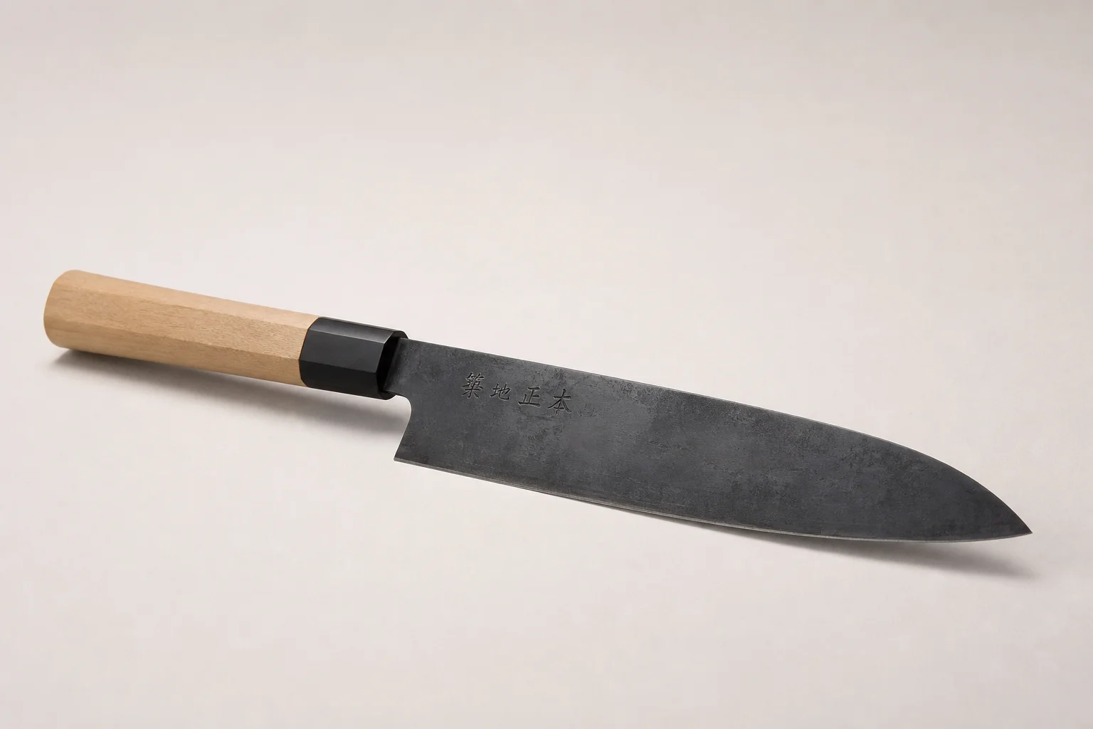 Professional kitchen knives and tools arranged on concrete surface