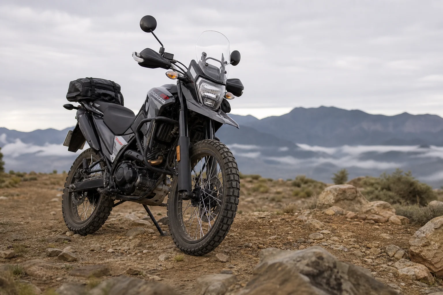 Dual sport motorcycle parked on rocky terrain with visible wheel and tire