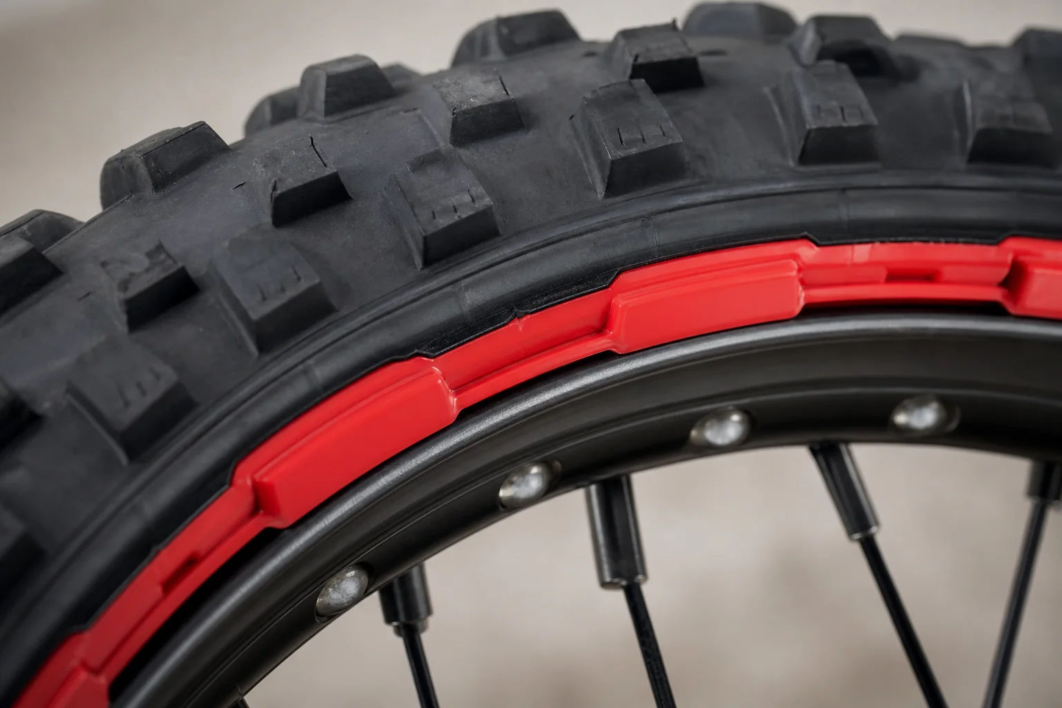 Close-up of motorcycle tire bead on rim with red plastic TUbliss cover visible