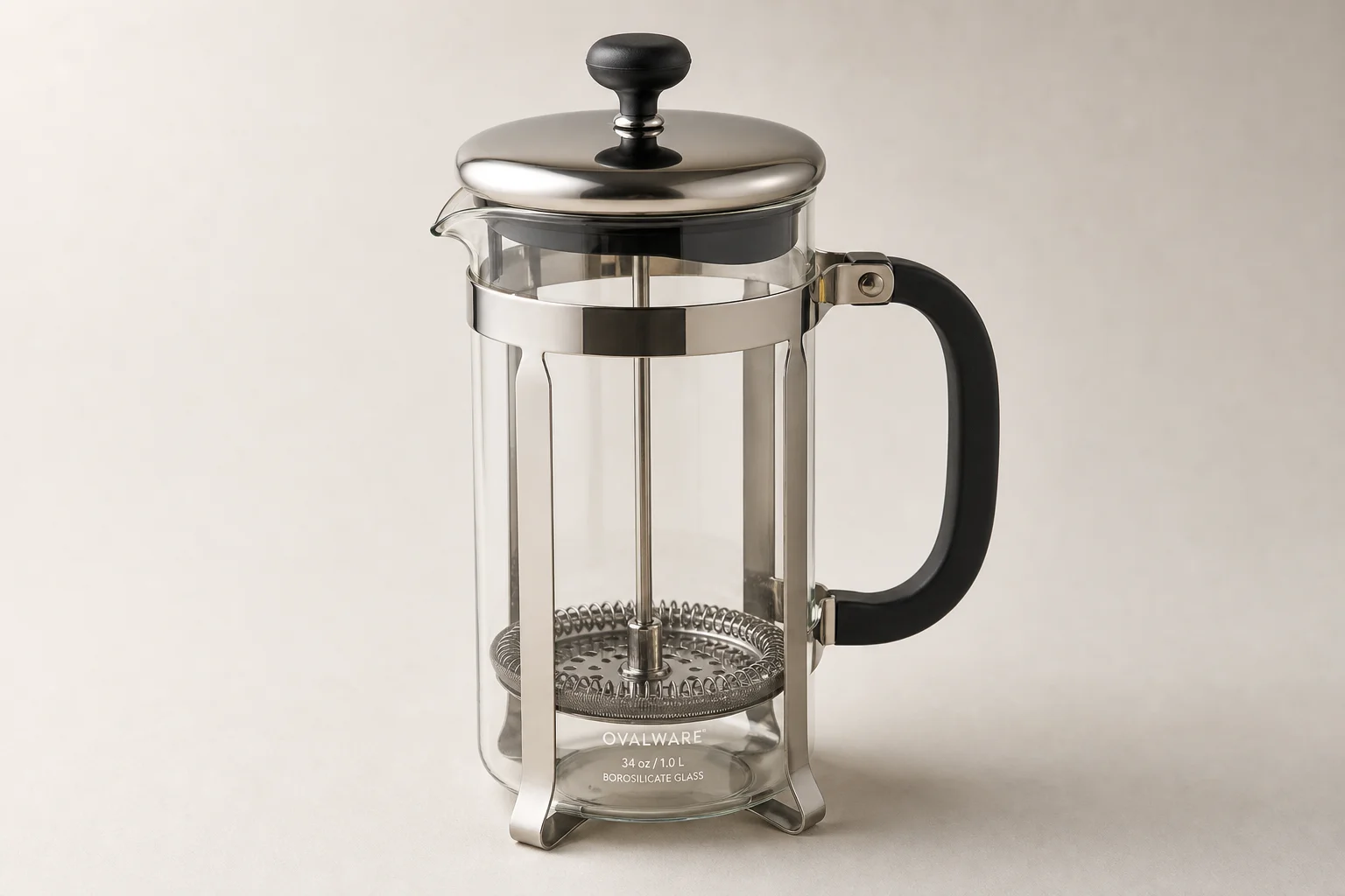 Five French press coffee makers arranged on concrete surface showing different sizes and styles