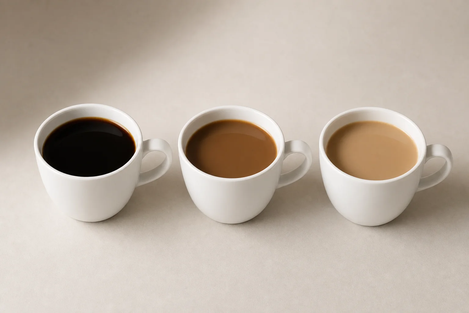 Three cups of brewed coffee showing different color intensities