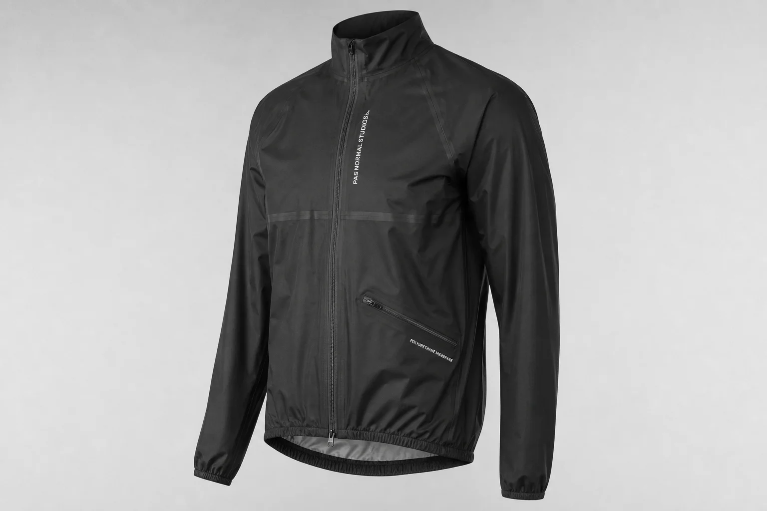 Cinq vestes de pluie pour le cyclisme de différentes couleurs disposées sur un fond neutre