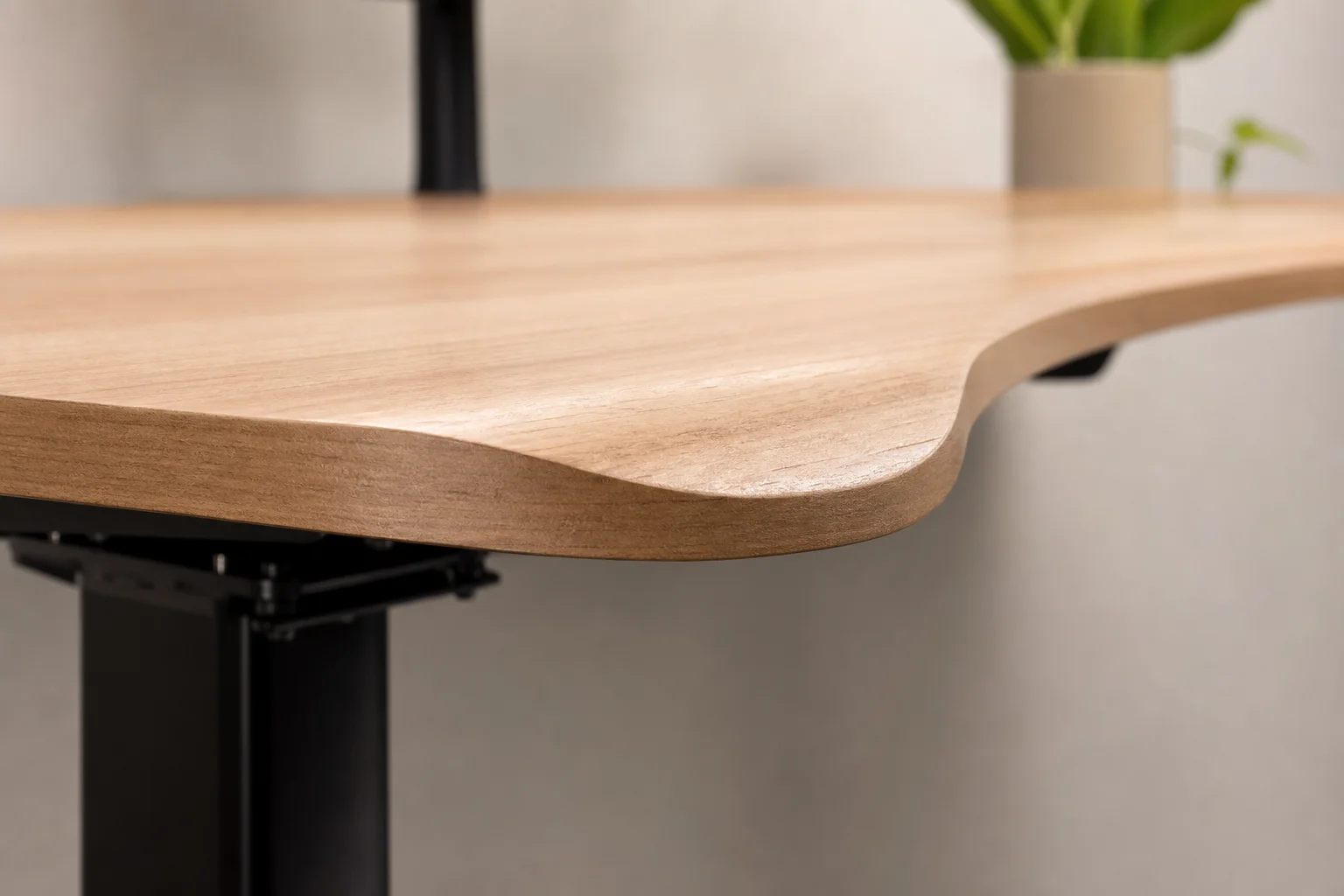 Close-up of the curved front edge of a standing desk where it meets a person's arm