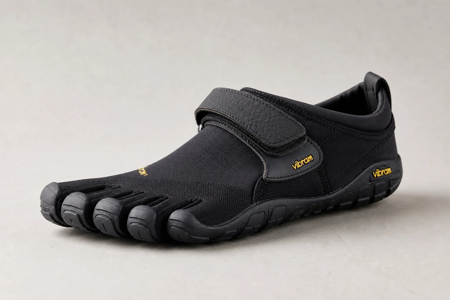 Sette modelli di scarpe barefoot disposti su una superficie in cemento
