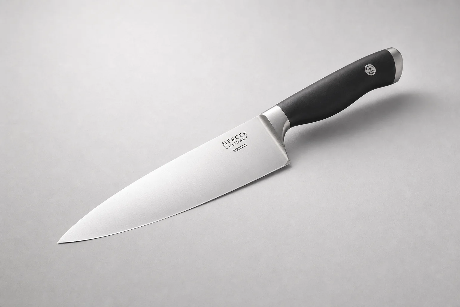 Eight essential kitchen tools arranged on a light wood surface