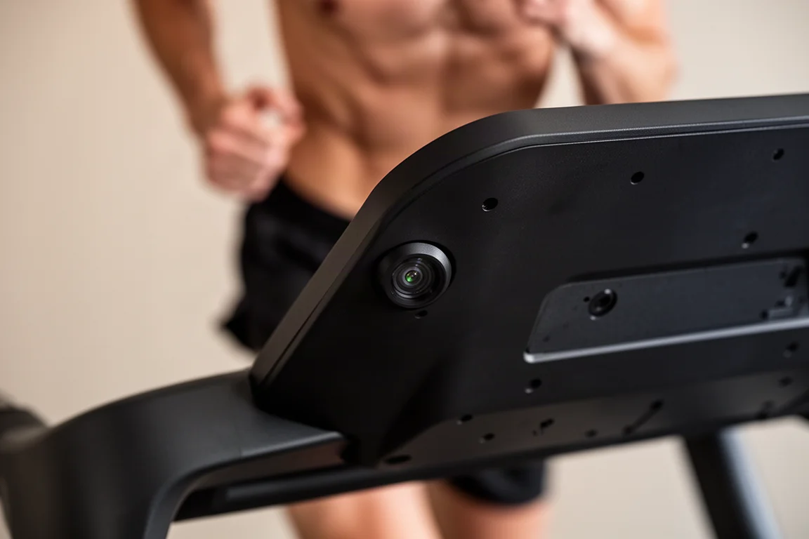 Close-up of a treadmill console sensor aimed at a runner's waist position