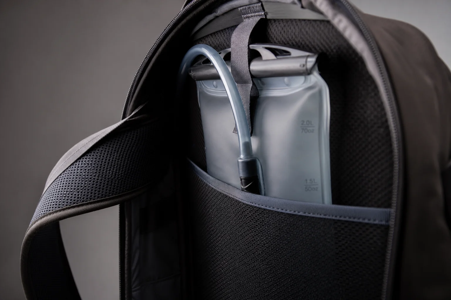 Water bladder positioned inside backpack against back panel