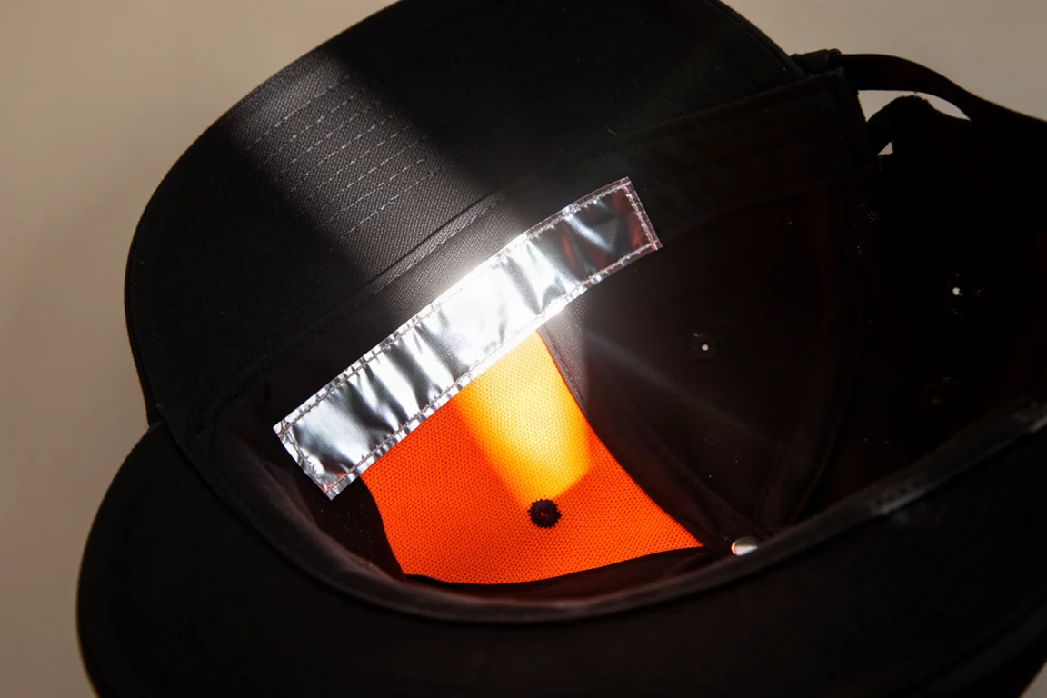 Reflektierender Silberstreifen im Inneren einer Kappe, der helles Licht einfängt