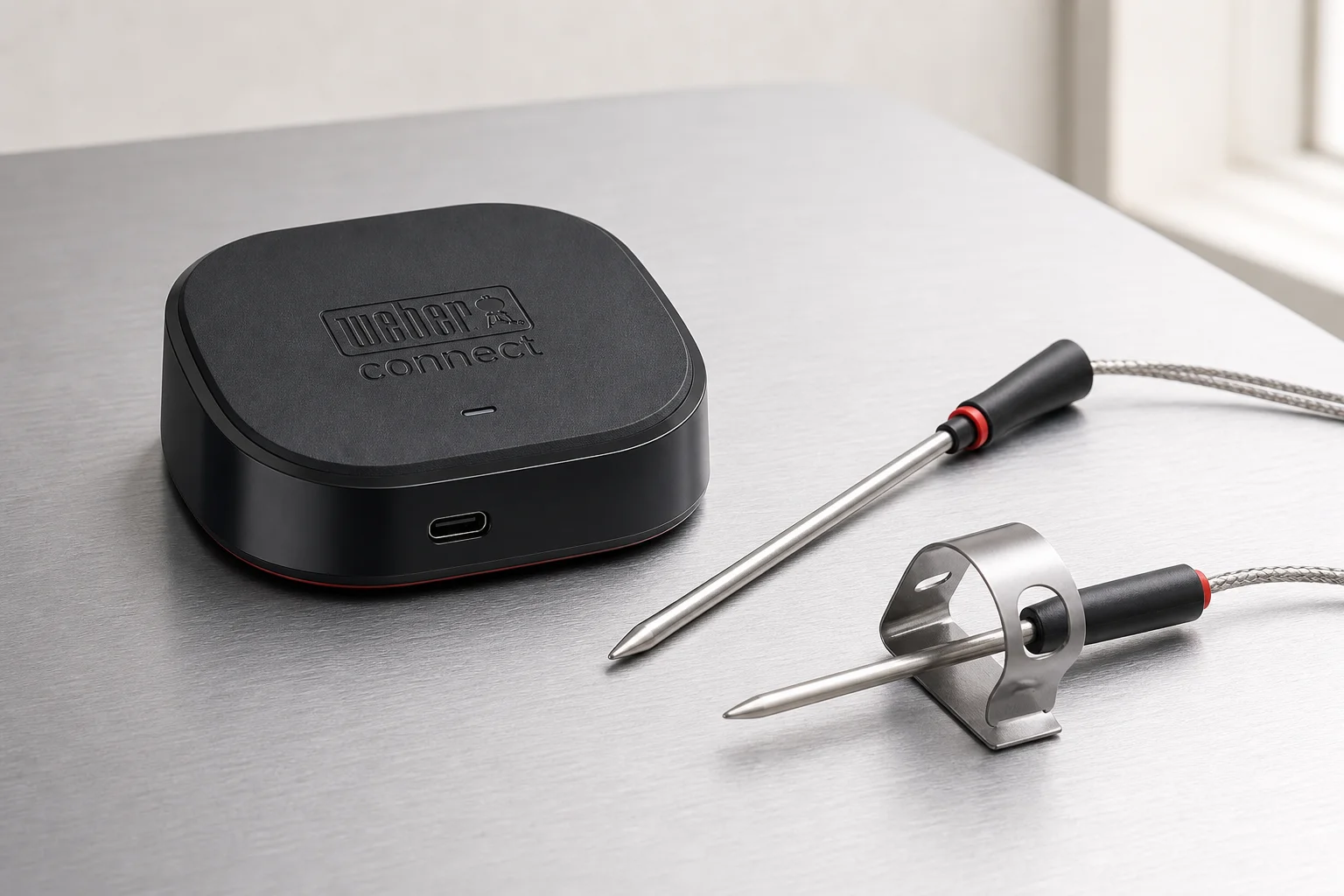 Three smart meat thermometer systems displayed on concrete surface