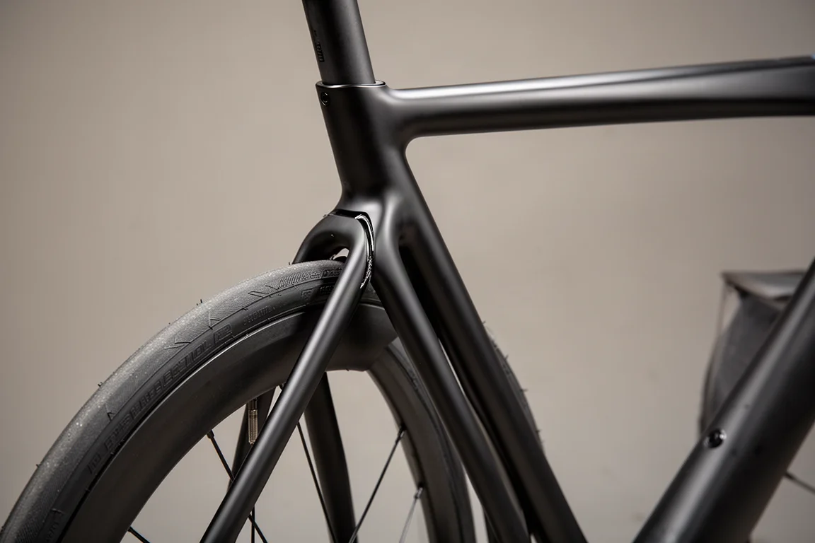 Breites Carbon-Gravel-Laufrad mit Stollen-Tubeless-Reifen auf feuchtem Schotterweg