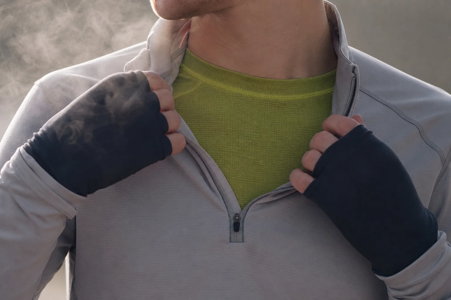 Gros plan sur un coureur portant une couche de base en mérinos vert citron et un haut zippé