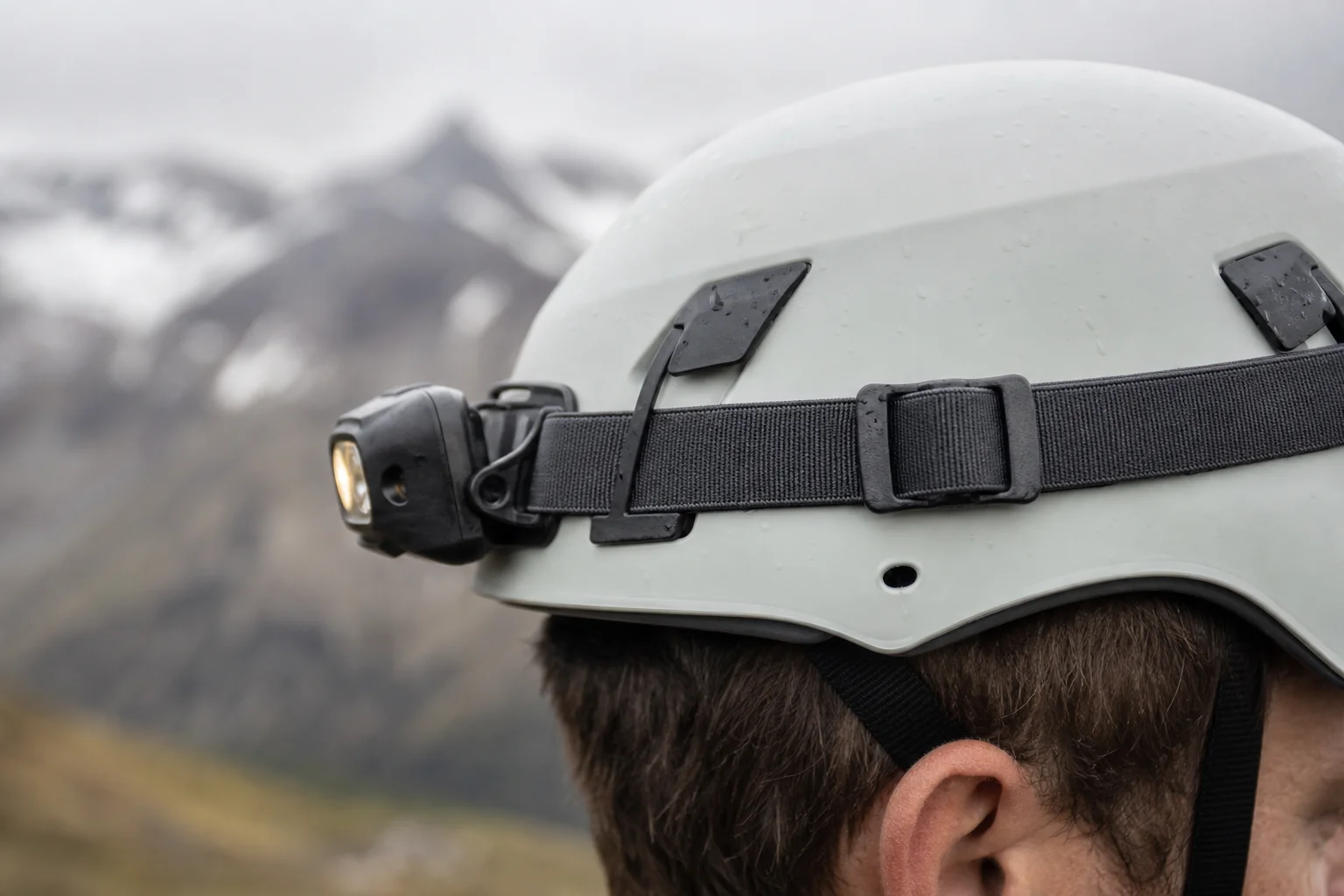 Nahaufnahme eines Stirnlampenbands an einem Wanderhelm unter Outdoor-Bedingungen