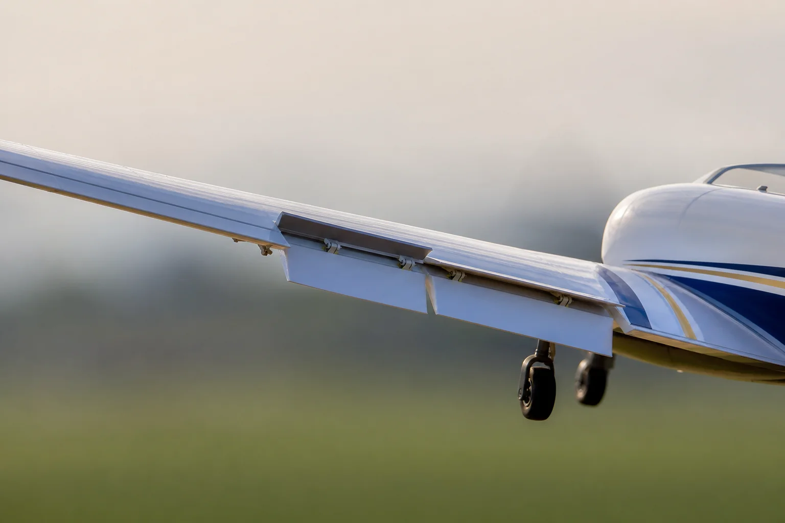 Close-up detail of RC aircraft wing flaps deployed during approach