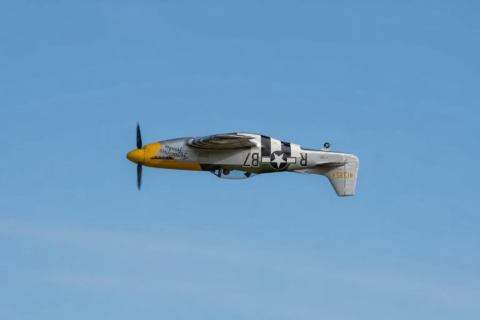 RC-Flugzeug bei einem Rückenflugmanöver vor blauem Himmel