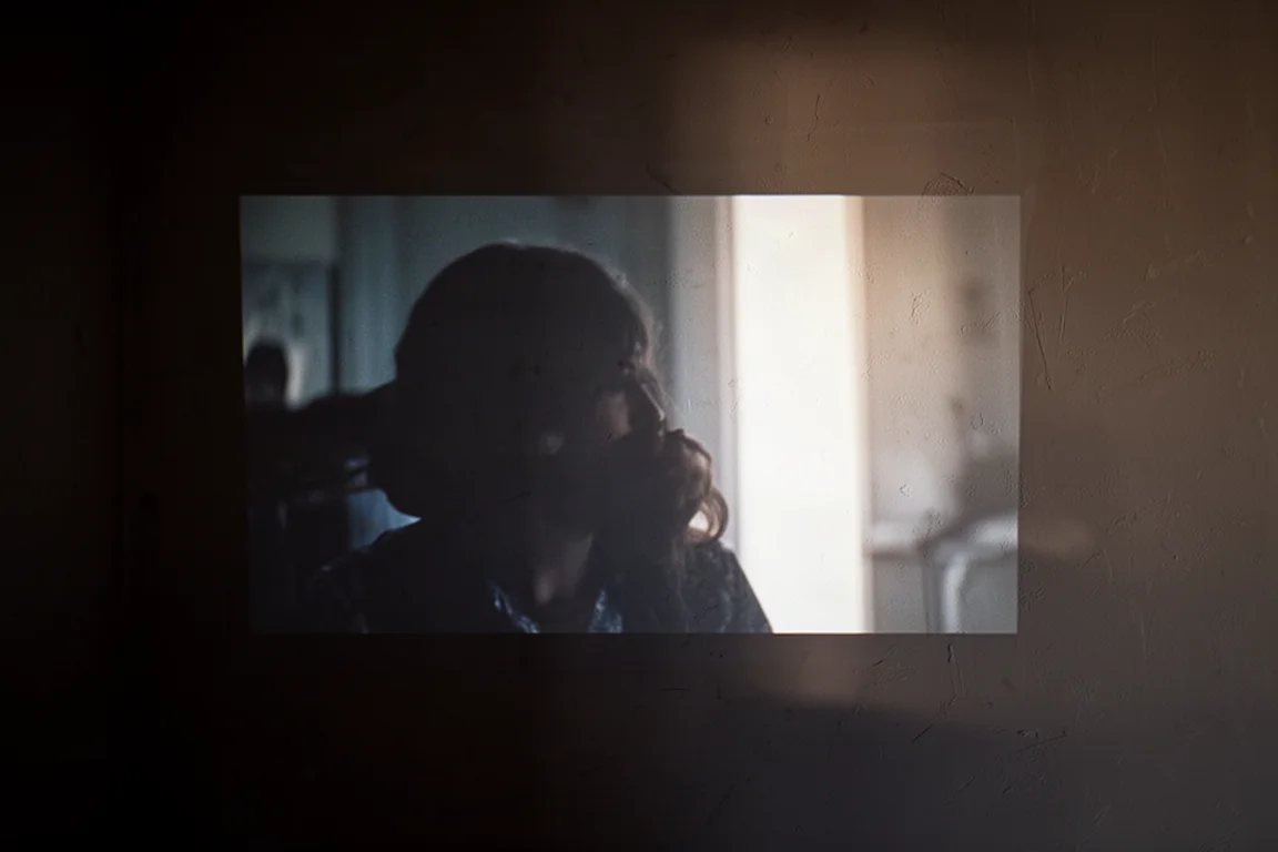 Ciemna ściana z projekcją sceny filmowej ukazującą głębokie szczegóły cieni