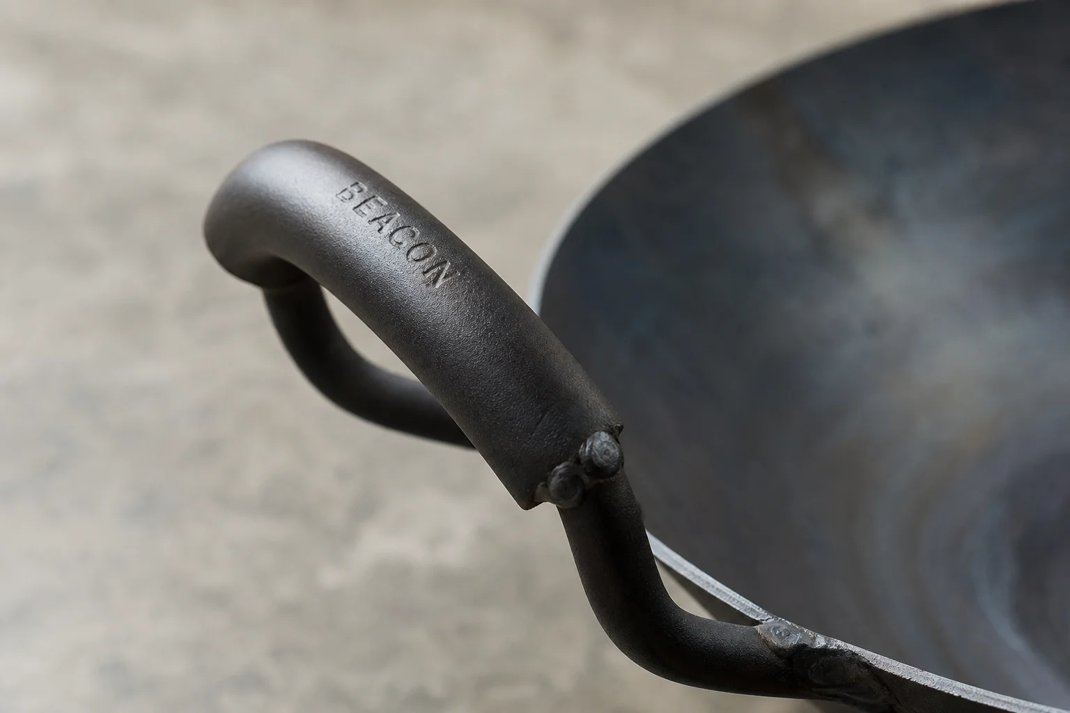 Close-up detail of a wok handle showing solid construction and grip design